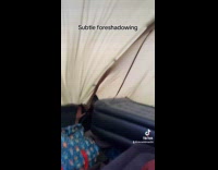 Subtle foreshadowing man in tent blown by wind