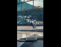 Guy stand on bike balance tire on head