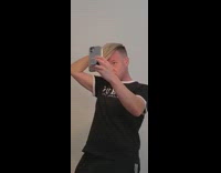 Black guess shirt guy fixes hair mirror 