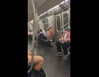Red shirt guy looks at phone subway 