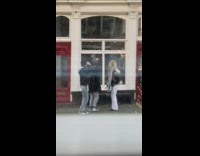 Three women spin around outside window street 