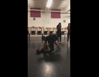 Guy tries to lift green shirt after he runs and jumps, drops him on his back hard on floor