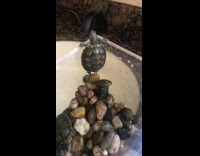 Turtle climbs side of container above sink and falls on its back shell and lands on rocks