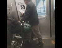 Man with bike on subway train reads book, rips out pages and stuffs them inside coat pocket