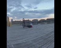 guy back flip bike on beach pier 
