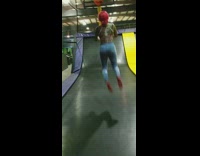 Woman with red hair jumps on trampoline, shoots basketball and misses completely