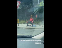Guy wearing red boxing gloves sits on sidewalk 
