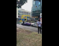 Man gets out of the violet sports car for a photoshoot