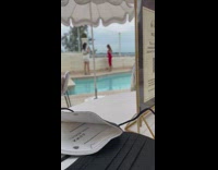 Woman red dress raise foot pool umbrella