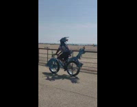 Guy rides blue dragon bicycle hat beach 