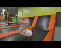 Man jumps and front flips on the trampoline