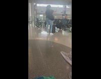 Woman holds a belt to her luggage for a tiktok hack video