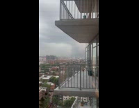 Woman shows dark clouds from apartment window