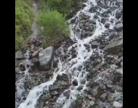 Drone flies over waterfall creek mountain street