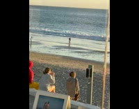 Two women white dress same outfit dance beach