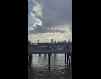 Man Rides Bike on Pier with Trash on Head