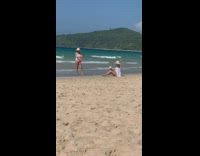 woman sits beach holds coconut