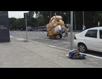 Woman pulls box filled cart down street