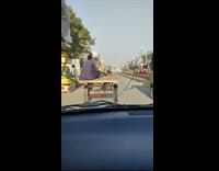 Donkey pulls guy sitting on cart
