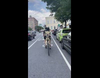 Biker rides with skeleton behind him 