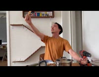 Man moves spoon with sound from the drill like a robot