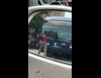 Man blocking bus on street pulling out wiper