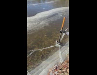 Guy uses axe to break frozen ice lake 