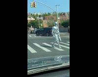 Silver human statue guy crosses the street 