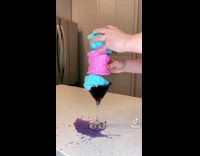 Putting pink and blue cotton candy into martini glass