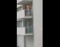 Woman purple underwear pose on apartment balcony. 