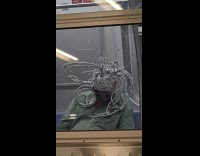 Man wearing strange head dress on subway
