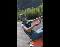 Guy orange dirt bike wheelie road helmet 