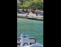 Woman black onesie headstand on bridge beach