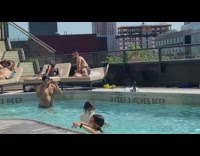 Man in the pool shadow boxes with kids nearby