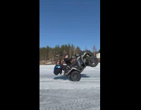 Three guys balancing on an ATV doing wheelie in snow