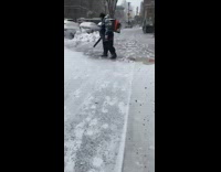Guy uses leaf blower on sidewalk snow 