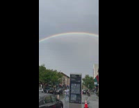Rainbow in brooklyn late in the afternoon along street