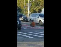 Orange shirt guy sits down street road 