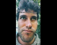 Green eyed man twirls and smiles with camera