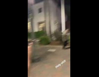Drunk guy in suit trying to skateboard pushed by woman 