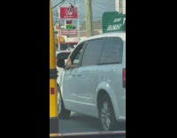Man foot outside window of his car while drive