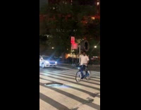 Guy rides bike with TV on head