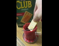 Guy dips club cracker in lit candle 