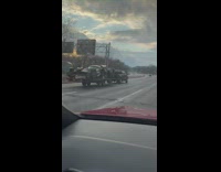 Batmobile being towed by a black truck