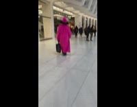 Guy wears long pink coat and hat