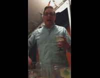 Drunk guy blue button up shirt singing IDGAF with margarita drink in hand