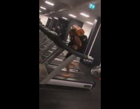 Shirtless shoeless man runs on treadmill ay gym with camping gear  and backpack on his back