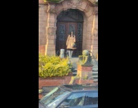 Woman brown coat front door golden hour