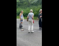 Elderly ladies helping turtle cross street