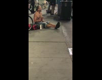 Shirtless guy streets singing drums singing gibberish 